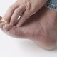 A person experiencing neuropathy symptoms in their foot